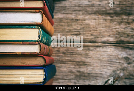 Old books stacked on wooden background - copy space Stock Photo