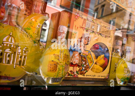 Horizontal close up of a window display of decorative limoncello bottles. Stock Photo