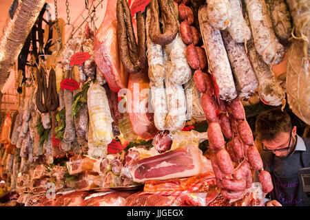 Horizontal view of various salami and sausages hanging up at a charcuterie shop. Stock Photo