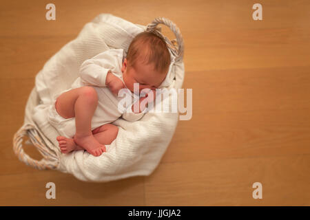 Newborn baby boy sleeping in a basket Stock Photo