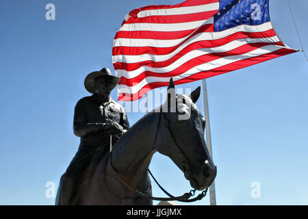 A statue of Bob Funk, founder of Express Ranches, stands with an American Flag in Yukon Oklahoma. Stock Photo