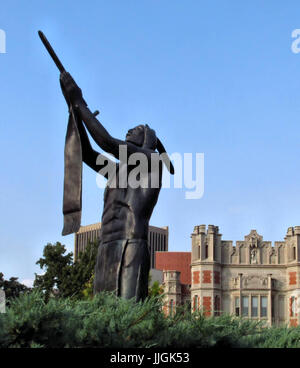 The Houser Peace statue of Native American man with a peace pipe stands at the entrance to the University of Oklahoma campus. Stock Photo