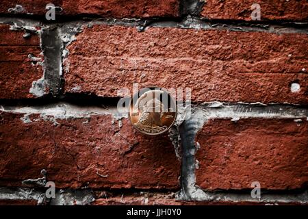 Digital currency physical gold titan bitcoin coin on the brick wall. Stock Photo