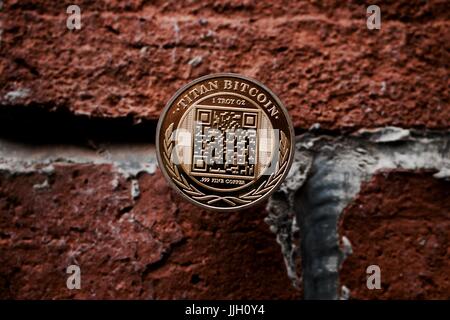 Cryptocurrency physical gold titan bitcoin coin on the brick wall. Stock Photo