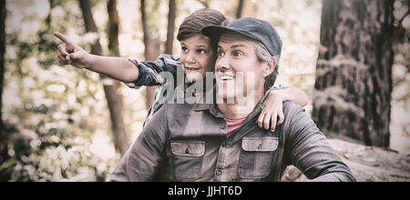 Curious boy showing something to father while hiking in forest Stock Photo