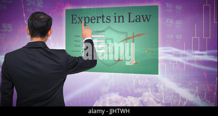 Asian businessman pointing against stocks and shares Stock Photo