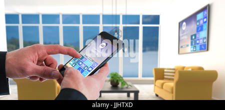 Businessman using smart phone against yellow sofas on floor in modern living room Stock Photo