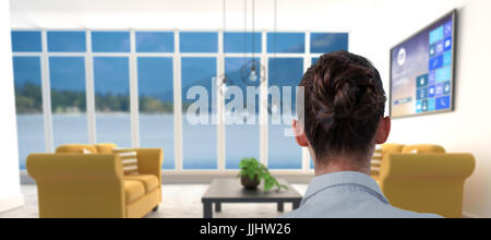 Rear view of businesswoman sitting on chair against yellow sofas on floor in modern living room Stock Photo