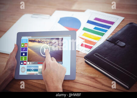 Composite image of various video and computer icons against over shoulder view of hipster woman using tablet Stock Photo