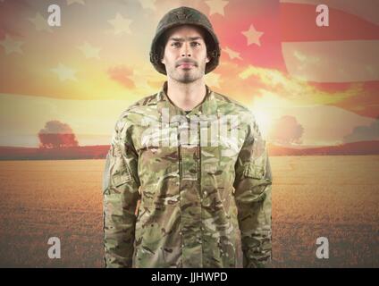 Smiling soldier standing on american flag background Stock Photo