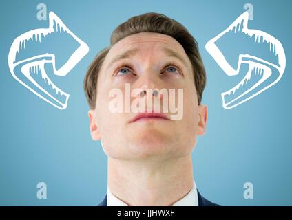 Man looking up at white 3D curved arrows against blue background Stock Photo