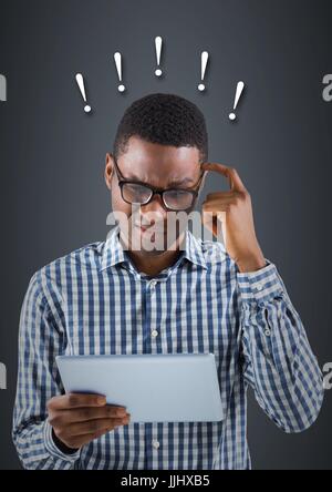 Frustrated business man with 3d tablet against blue background and exclamation points Stock Photo