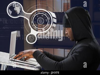 Side view of hacker using a laptop on a table in front of 3D digital background Stock Photo