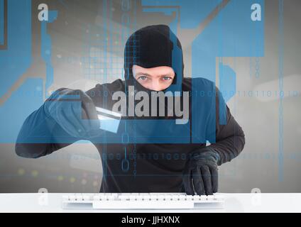 Hacker with credit card using a laptop behind digital screen Stock Photo