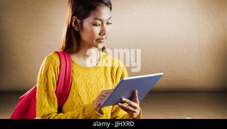 College student with tablet against brown wall Stock Photo