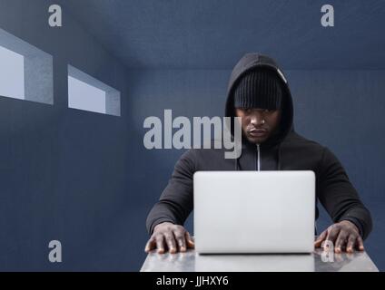 Hacker working on laptop in dark room Stock Photo