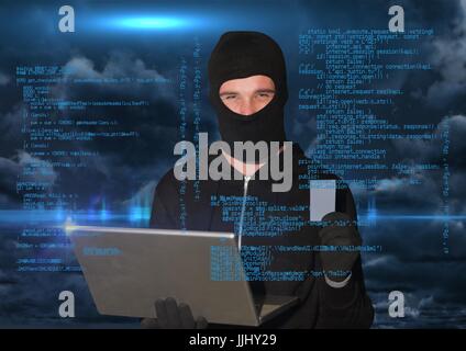 Hacker working on laptop in front of blue digital background Stock Photo