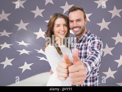 couple thumbs up against fluttering american flag Stock Photo