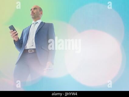Businessman texting in lights Stock Photo
