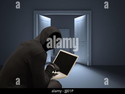 Shadow of hacker using a laptop in a dark room Stock Photo