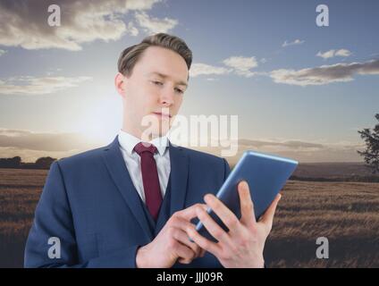Man using a digital tablet in the countryside Stock Photo