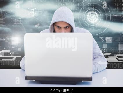 Hacker using a laptop in front of digital background Stock Photo