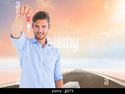 Man Holding Keys with road Stock Photo