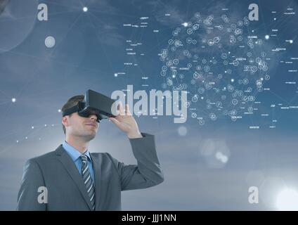 Man in VR headset looking to an interface against blue sky with flares Stock Photo