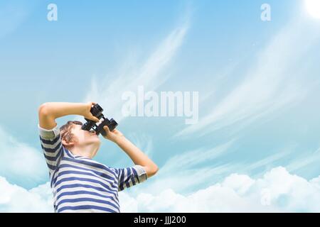 Boy looking through binoculars against sky Stock Photo