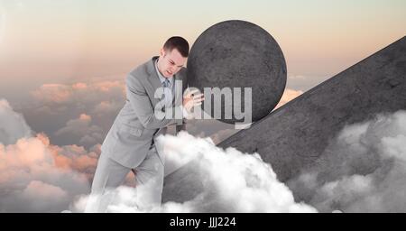 Man pushing rolling round rock Stock Photo