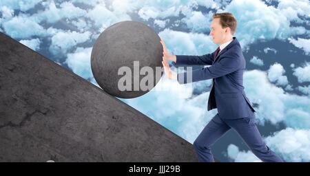 Man pushing rolling round rock Stock Photo