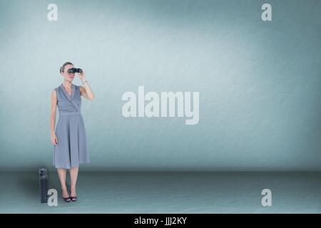 Woman looking through binoculars against blue background and copy space Stock Photo