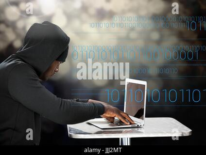 Hacker using a laptop in front of digital background Stock Photo