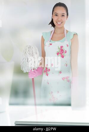 Cleaner holding mop with bright background Stock Photo