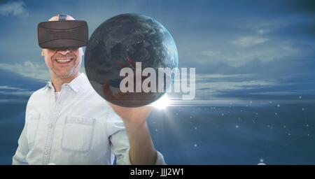 Happy man in VR touching 3D planet with flares against blue sky Stock Photo
