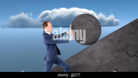 Man pushing rolling round rock Stock Photo