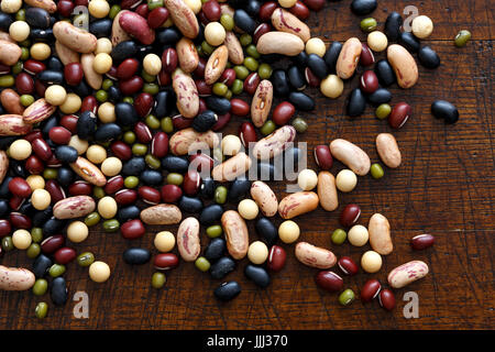 Mixed dry beans on dark wood from above. Stock Photo