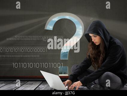 Woman hacker seated and working on a laptop with a grey background with a 3D question mark Stock Photo