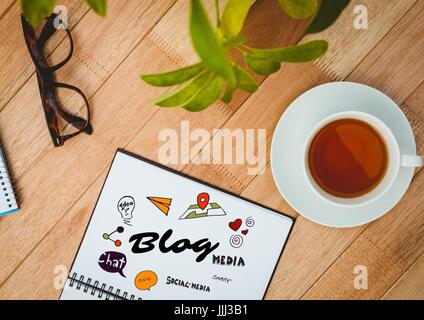 Blog doodle on notepad next to tea, glasses and plant Stock Photo