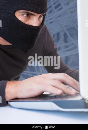 Close up of hacker working on laptop Stock Photo