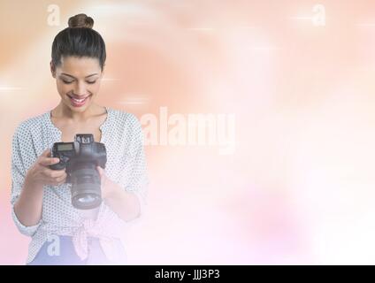 Smiling photographer looking at her camera in fog Stock Photo