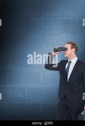 Man looking through binoculars against blue copy space wall Stock Photo