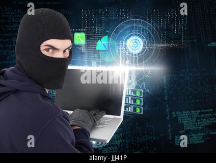 Hacker looking the lens and using a laptop in front of digital background Stock Photo