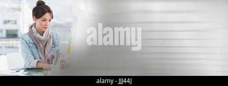 Innovative millennial at computer with blurry grey transition Stock Photo