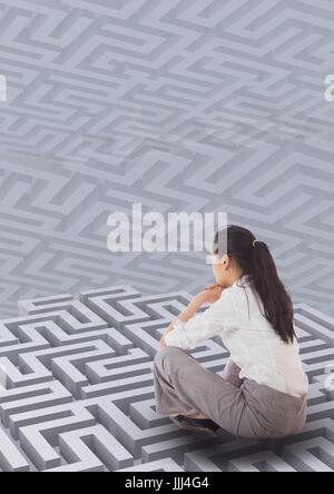 Woman sitting on a 3d maze against background with mazes Stock Photo