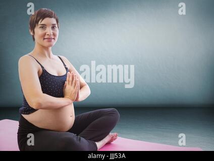 Woman meditating against blue wall Stock Photo