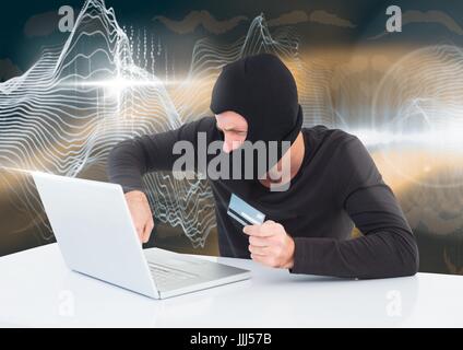 Hacker with a credit card working on laptop in front of digital background Stock Photo