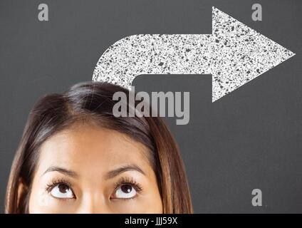 Top of woman's head looking up at white road arrow against grey background Stock Photo