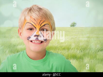 Boy with tiger facepaint against meadow with flare Stock Photo
