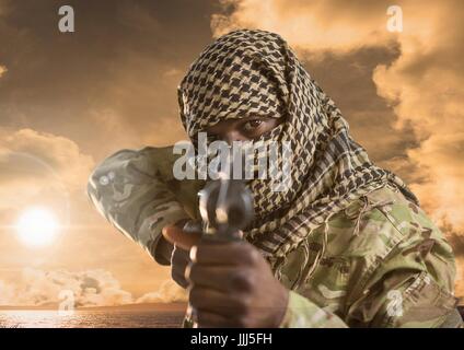 Military pointing with a gun against sunset
